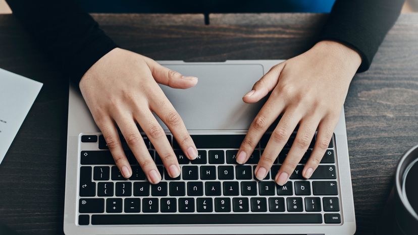 A woman typing on a laptop. 