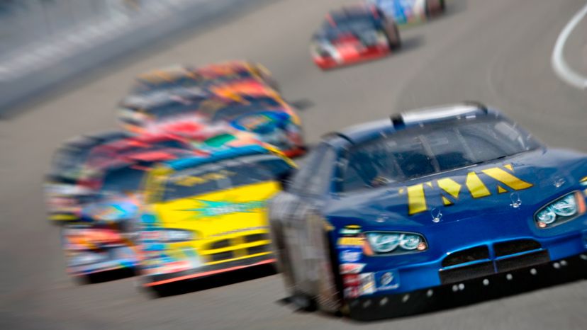 A blurry picture of cars racing on a race track. 
