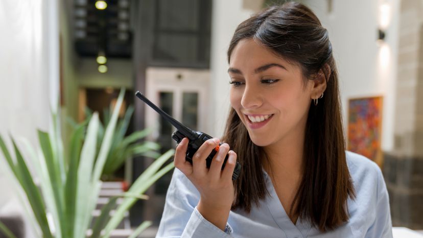 A woman taking into a walkie talkie. 