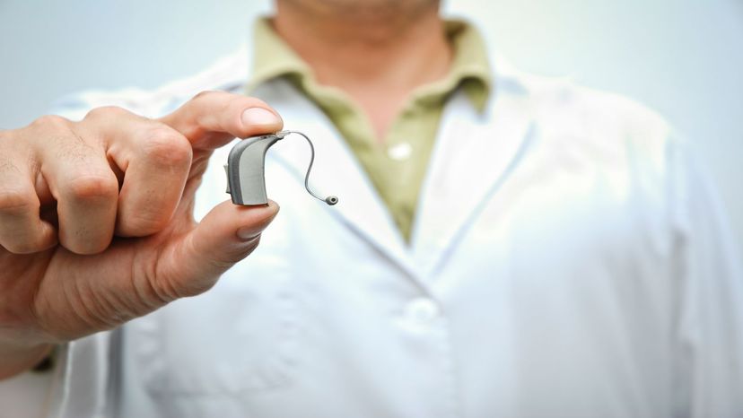 doctor holding hearing aid