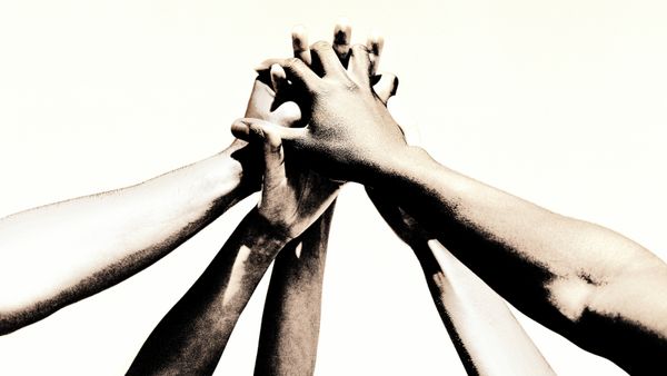 Different people holding hands to show a united front. 