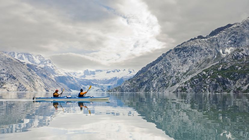 A man and woman kayaking across a river. 