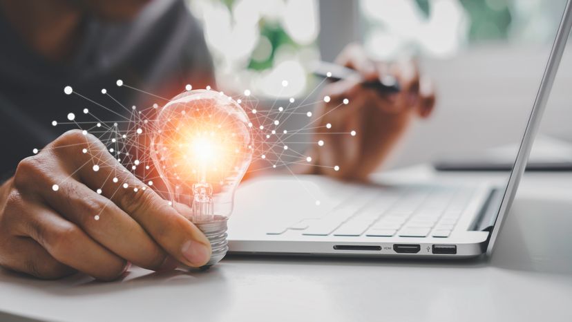 A mans hand holding a light bulb representing ideas. 