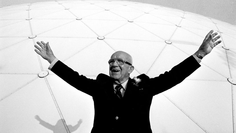 Bucky Fuller standing in front of a giant geodesic dome