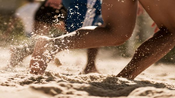 Bare feet running in sand