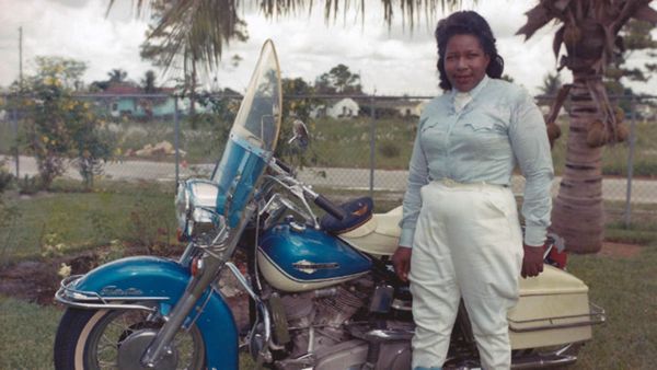 One adult man riding a motorcycle outdoors.