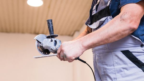 Man holding special machine for grinding ceramic.