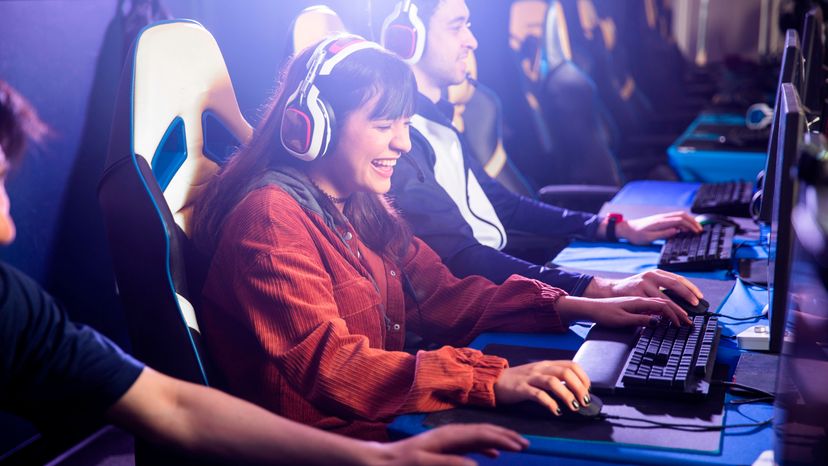 A group of teenagers playing video games on their PC. 