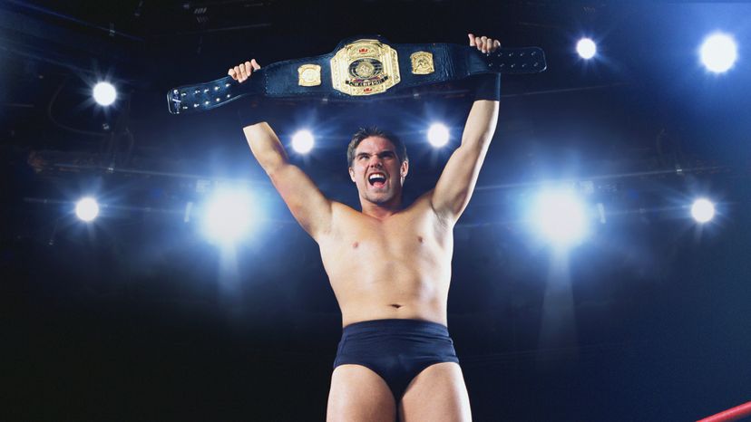 A wrestling champion holding up his championship belt.