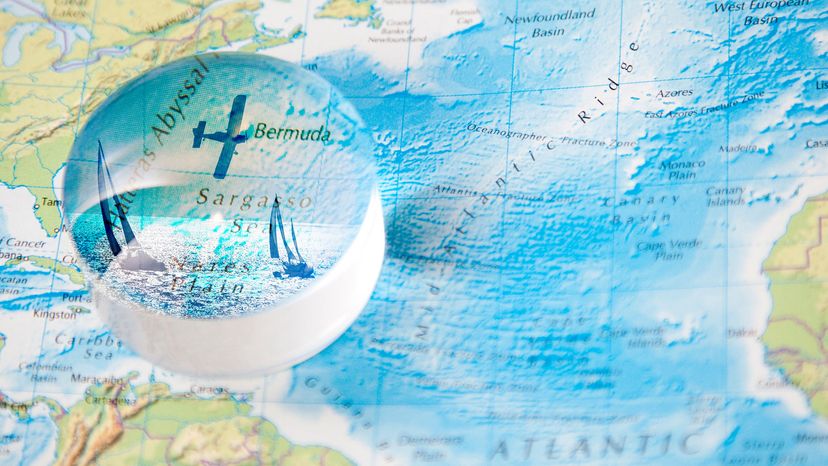 A magnifying globe shows a plane and boats over a map of the Bermuda Triangle