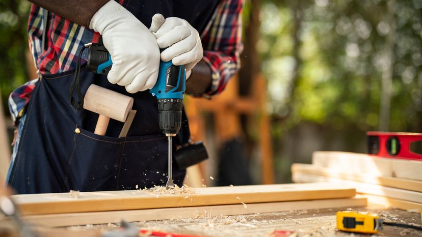 A metal drill bit making a hole in wood. 