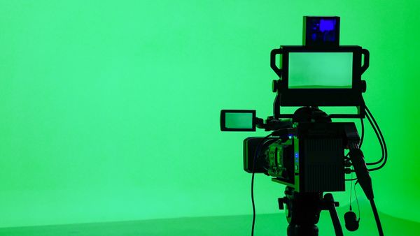 A camera placed in front of a green screen.