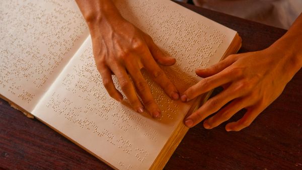 A blind man reading a braille book. 