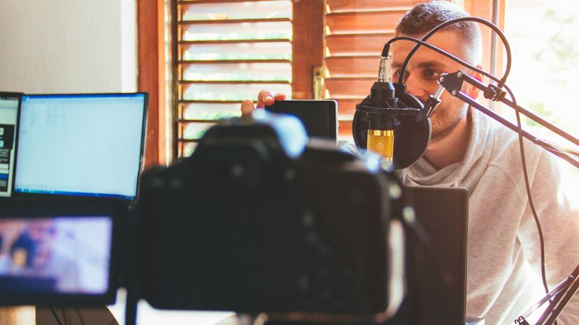 A young man recording a video while playing a game. 