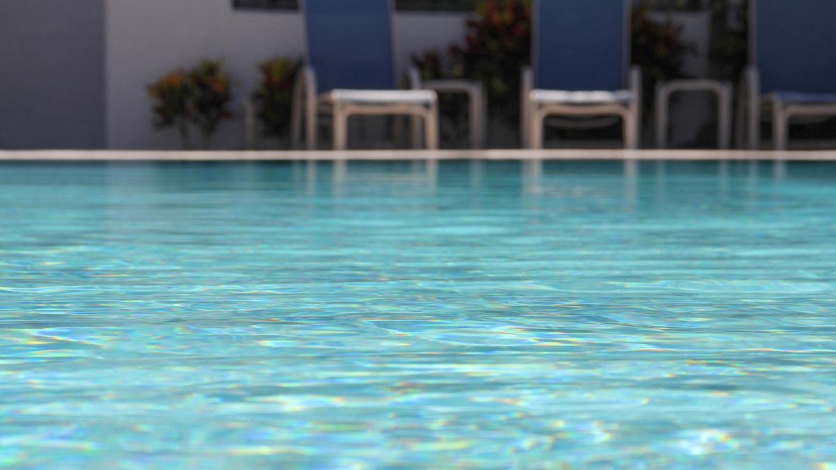 How does chlorine work to clean swimming pools?