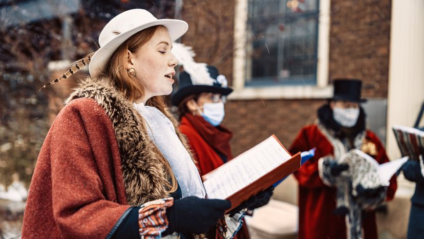 Carol singers performing on the street during Christmas.＂width=