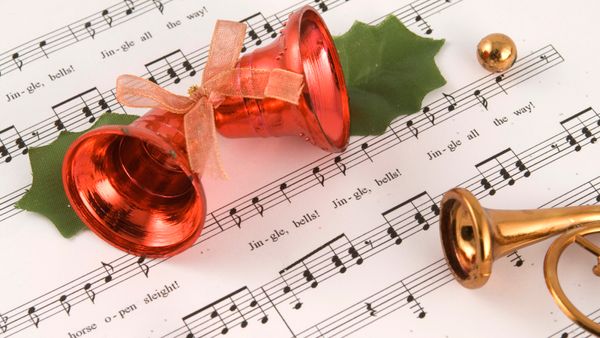 A bell and trumpet placed on a music sheet. 