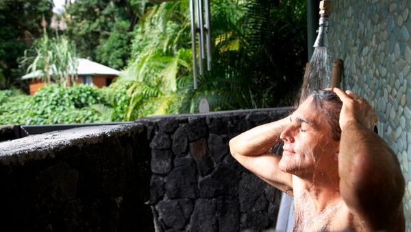 A man using an outdoor shower. 