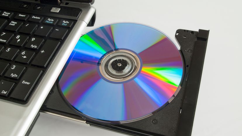 A CD ROM in the CD drive of a laptop. 