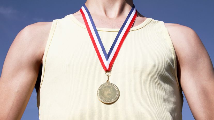 A close up of a man wearing a Gold medal. 