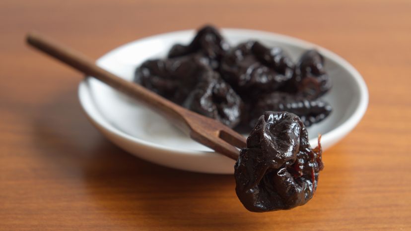 Dried plums on a saucer.