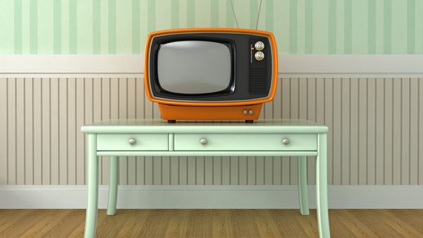 A retro style TV placed on a short table. 