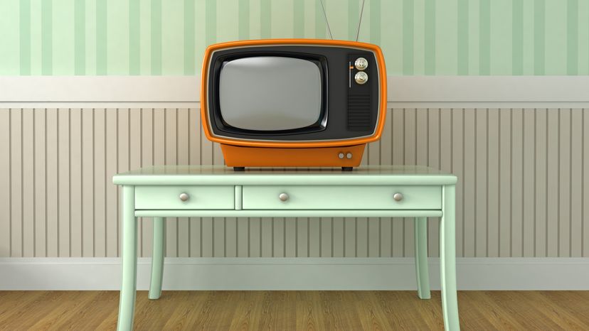 A retro style TV placed on a short table.