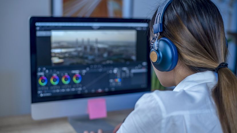 A woman in a studio, editing a video. 