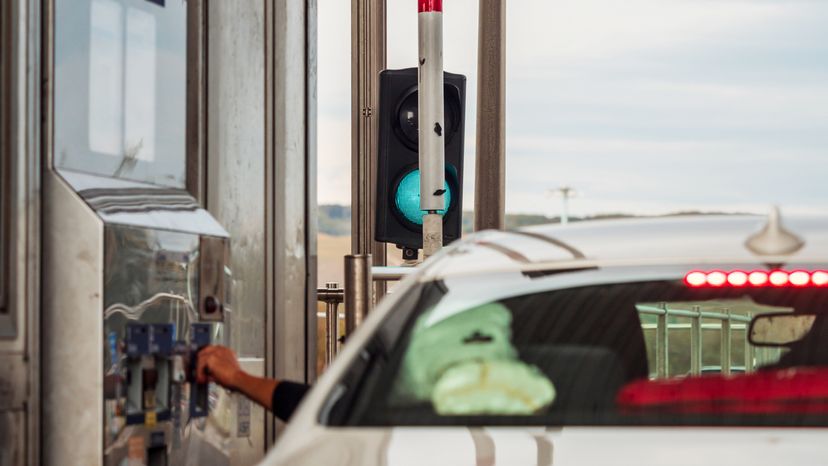 A driver paying the toll fare at a toll gate. 