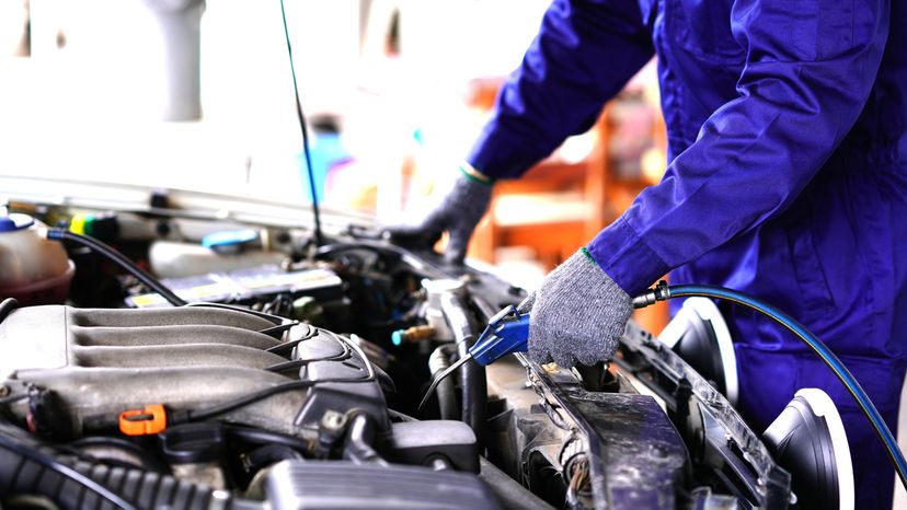 A mechanic using an air spray cleaner. 