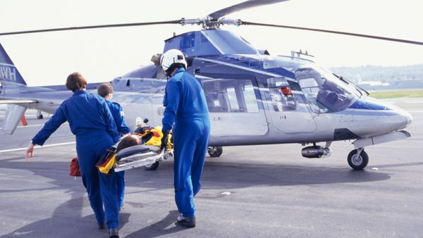 Medical responders carrying a patient to an helicopter on a stretcher.  