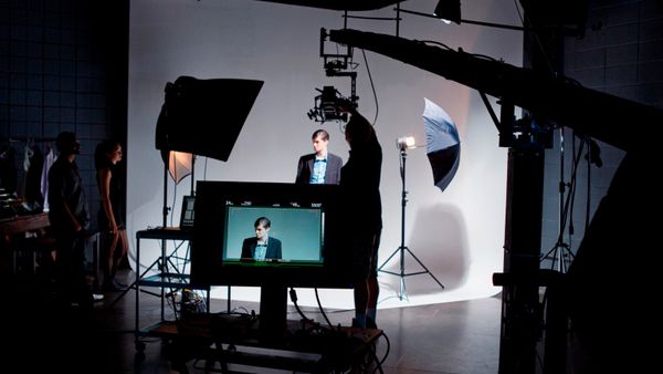 Model on a directors video screen, with film crew on set.