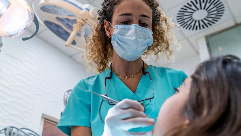 An image of a dentist examining a little girl. 