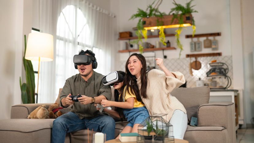 Father, mother and child having fun with VR headsets. 