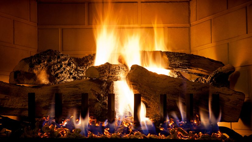 A closeup image of burning logs in a gas fireplace. 