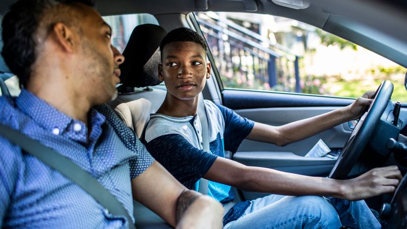 Father teaching son how to drive. 