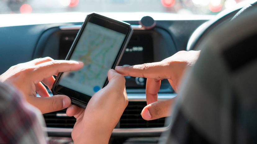 A cropped image of a driver using a map on a phone. 