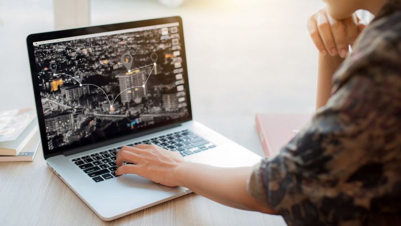 A woman looking at a map on her laptop. 