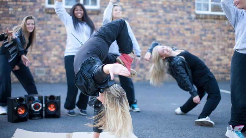 Young female dancer performing break dance moves. 