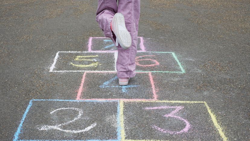 A girl playing hopscotch. 