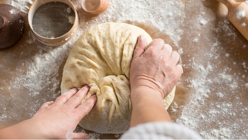 A woman kneading dough. 