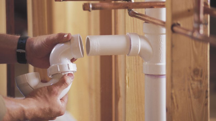 A hand holding a piece of PVC after removing it from another piece.