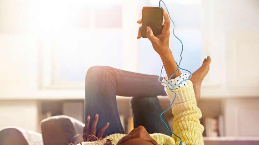 A young girl wearing an earpiece, listening to music. 