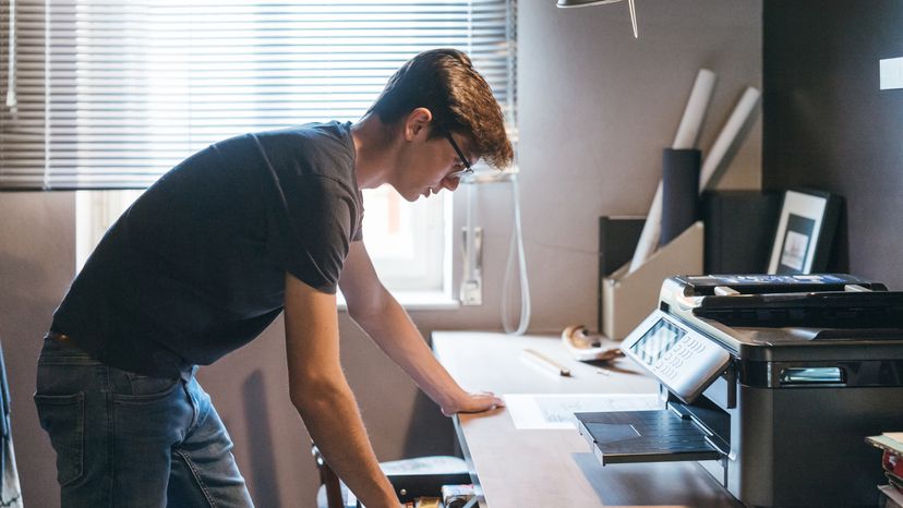 A man using a printer at home. 