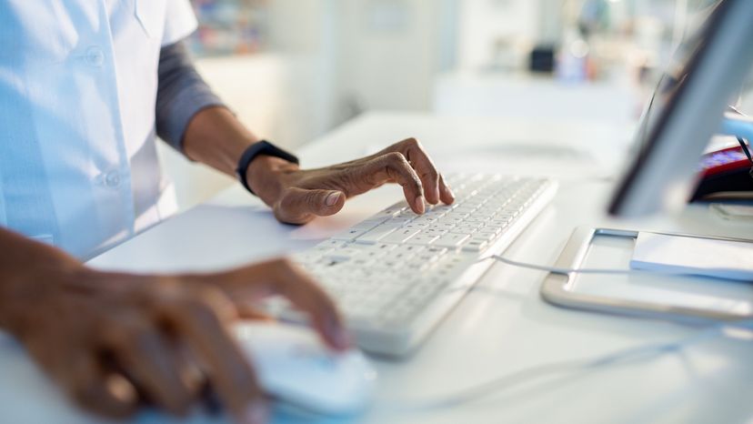 Close up image of a pharmacist working on his laptop. 