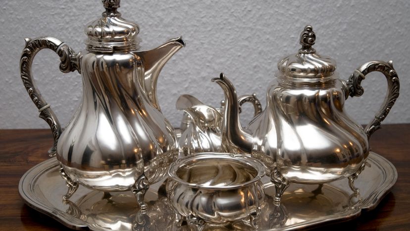 Silver tea kettles placed on a table.