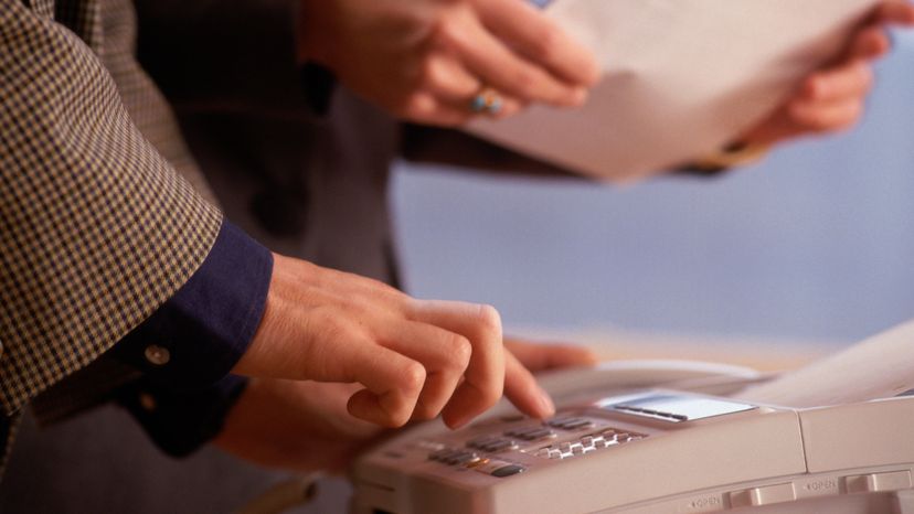 A woman using a fax machine. 