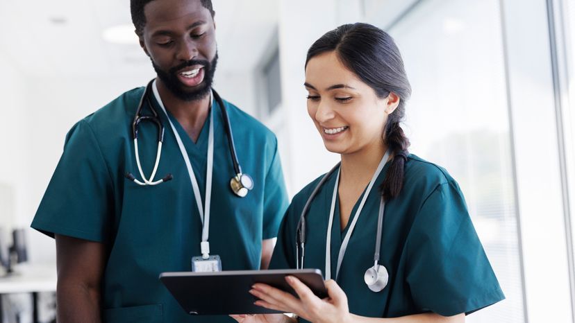 Two nurses holding a tablet.