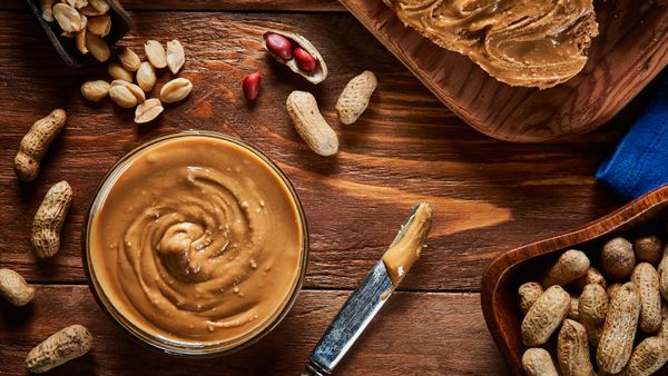 Top view of peanut butter in a bowl and on a slice of toast. 