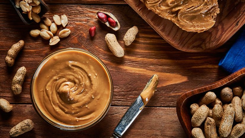 Top view of peanut butter in a bowl and on a slice of toast. 